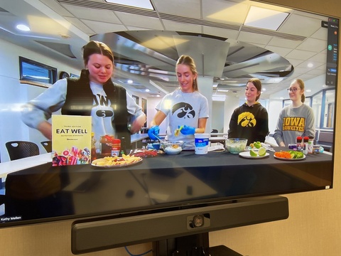 TV Screen showing students presenting on Zoom