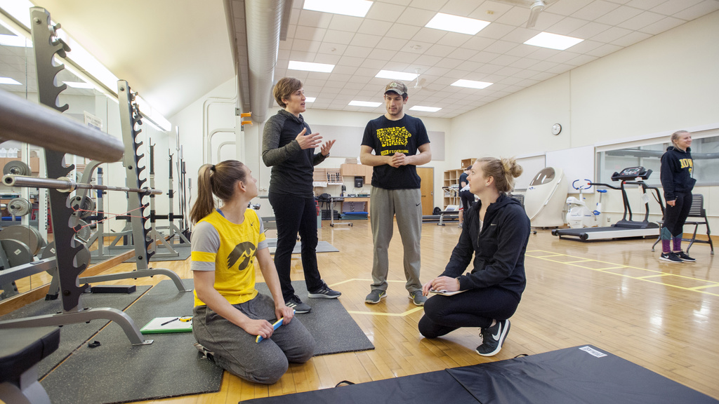students in a gym with equipment working on strength training