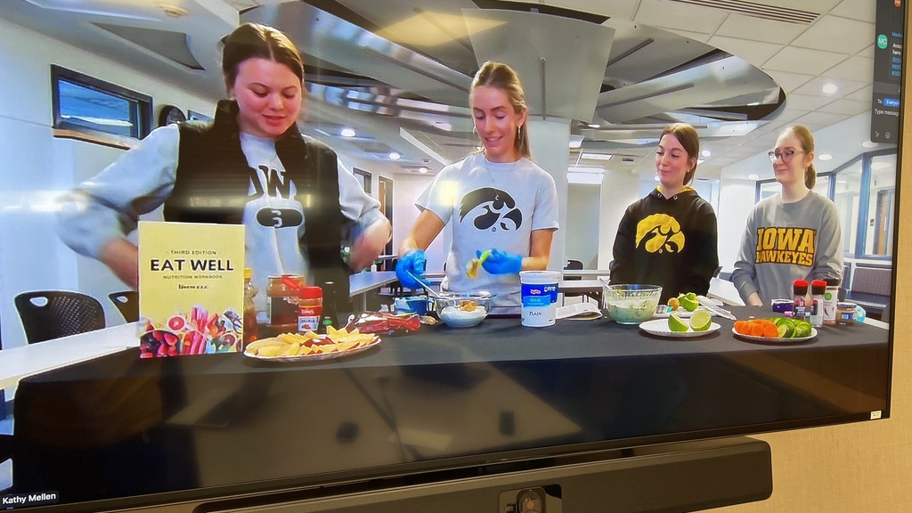 TV Screen showing students presenting on Zoom