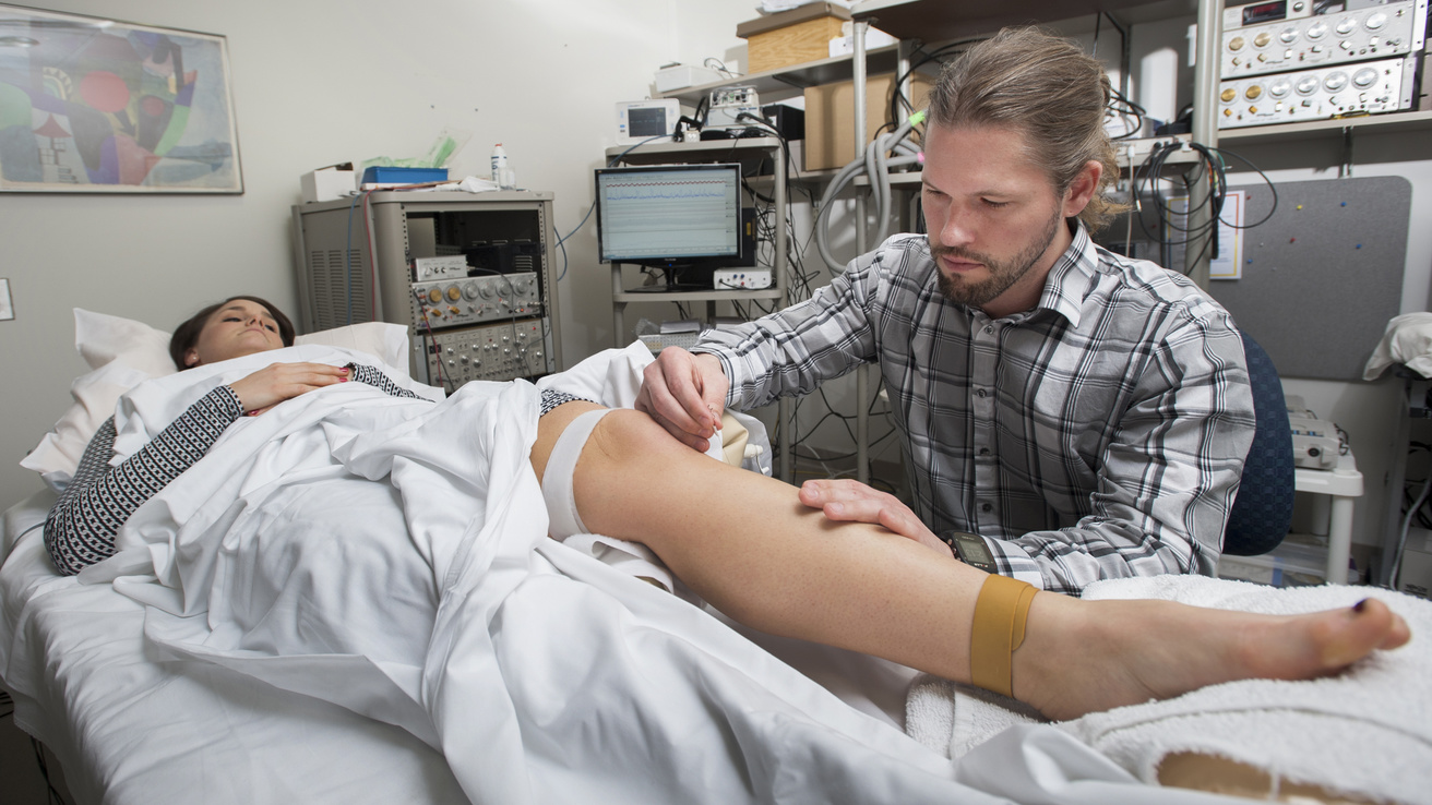 student doing a procedure on a patient's leg